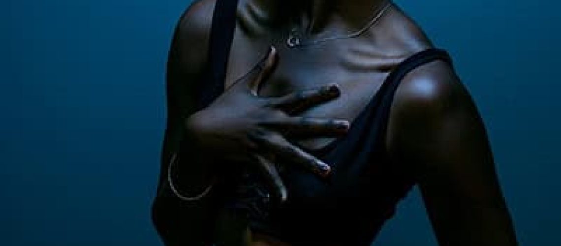 Moody boudoir image of young black girl in blue hue