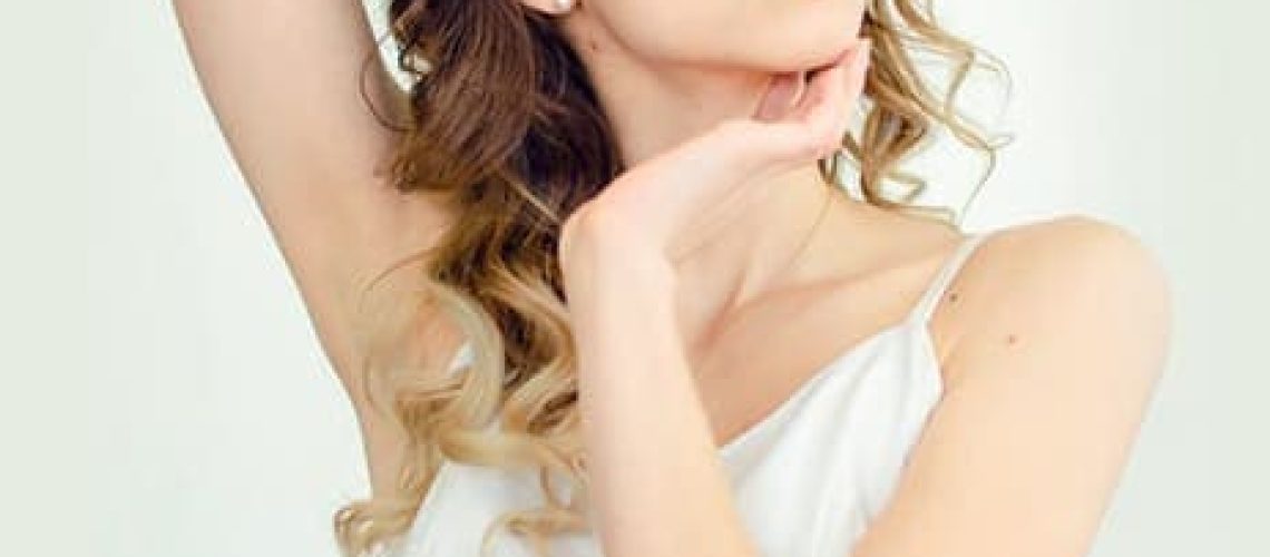 Young female model posing in white camisole